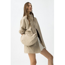 Chaqueta corta vientos, con cuello alto y cierre frontal oculto. Detalle bolso bandolera con diseño suave y ligeramente plisado