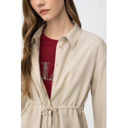 Camisa beige de corte relaxed, con cordón ajustable en la cintura y botones delanteros visibles.