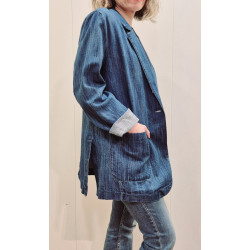 Chaqueta oversize con cuello de solapa clásico y cierre frontal de botones. Incluye dos grandes bolsillos de parche en la parte