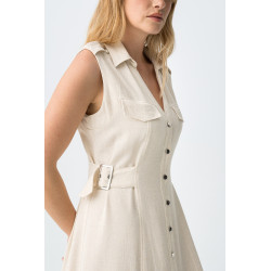 Vestido corte recto, sin mangas, botones delanteros, bolsillos en el pecho y cinturones laterales.