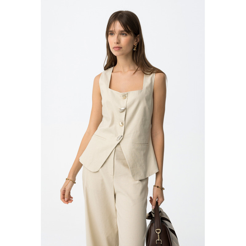 Top de color beige, corte ajustado, sin mangas, botones metálicos y dos bolsillos decorativos delante.