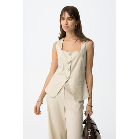 Top de color beige, corte ajustado, sin mangas, botones metálicos y dos bolsillos decorativos delante.