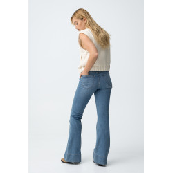 Vaqueros de corte flare en azul claro, con bolsillos delanteros y cierre de botón metálico.