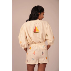 El diseño destaca por sus mangas de tres cuartos con volumen abullonado, que aportan un aire femenino y sofisticado sin restar c