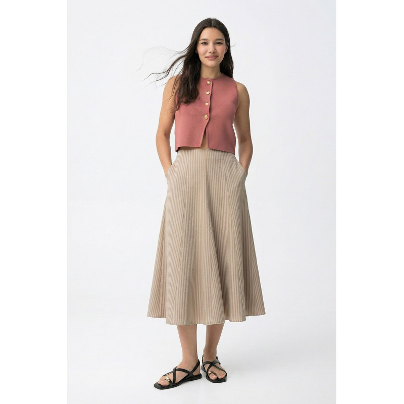 Falda de color beige, corte midi, caída amplia y pliegues finos en diseño relajado y casual.