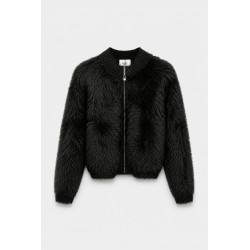 Chaqueta corta de tejido con textura de pelo largo. Cuello redondo y mangas largas de canalé. Ribetes de canalé y cierre de crem