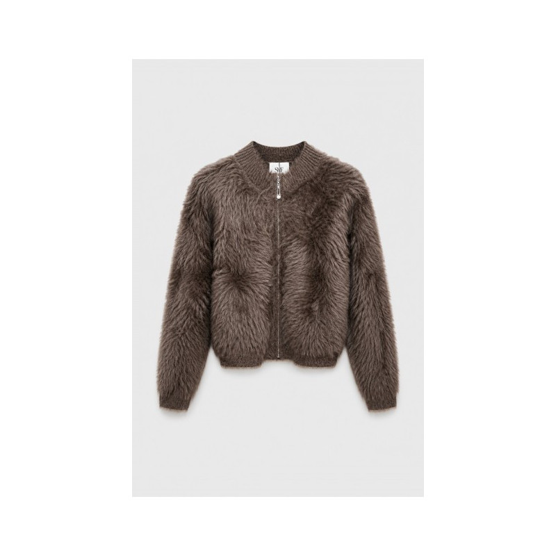 Chaqueta corta de tejido con textura de pelo largo. Cuello redondo y mangas largas de canalé. Ribetes de canalé y cierre de crem