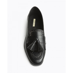 Mocasín para mujer con punta redonda y tacón plano. Detalle borlas y tachas