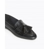 Mocasín para mujer con punta redonda y tacón plano. Detalle borlas y tachas
